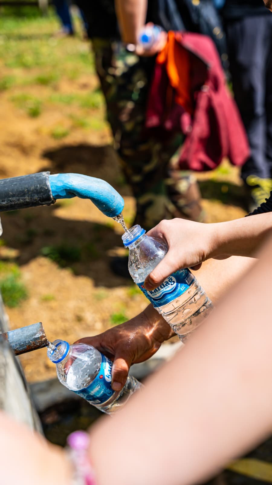 People filling water bottles from a tap